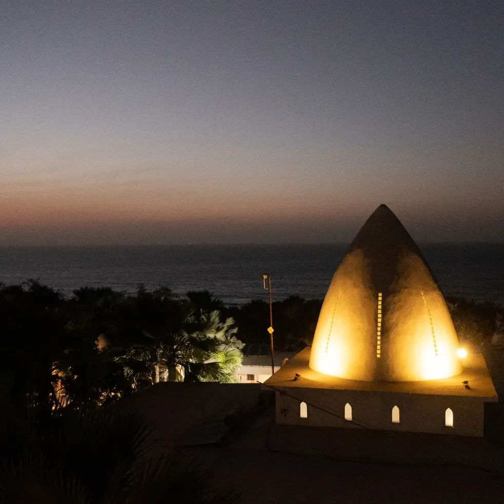 Coco Ocean iconic Moroccan dome lit at dusk, Atlantic Ocean behind
